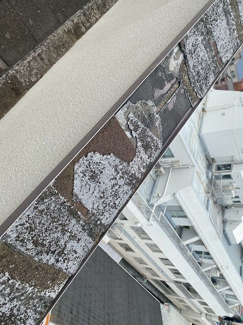 ひび割れと剥離が顕著な笠木表面